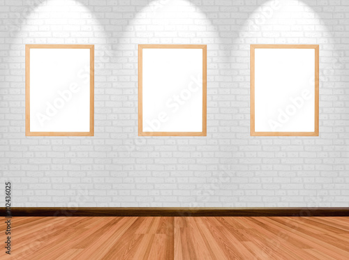 Empty frames on room background with wooden floor brick wall and spotlight.