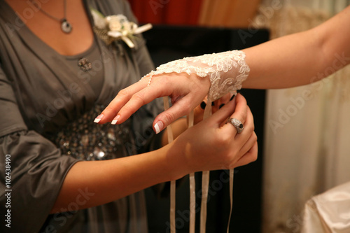 bridesmaid helps the bride to wear a bandage on his hand