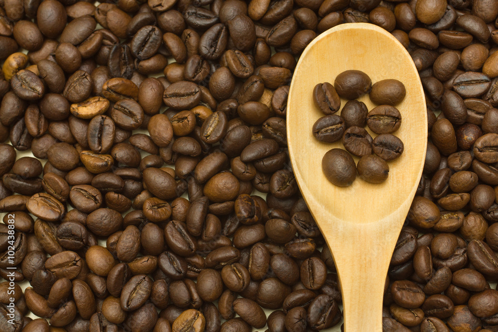 Fototapeta premium wooden spoon on coffee beans background