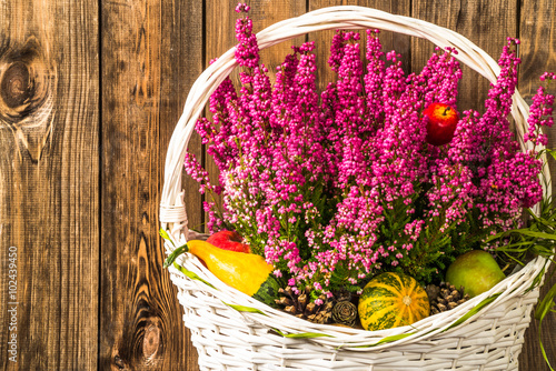 Heathers flowers in basket on rustic wood background