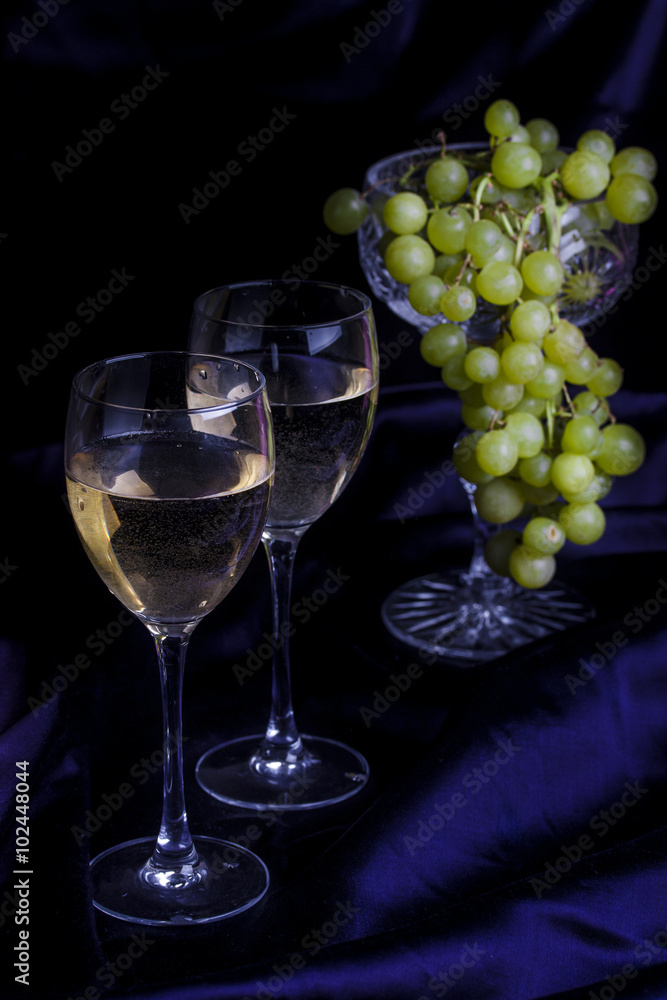Glasses of wine and grapes on a dark background Glasses of wine and grapes on a dark background