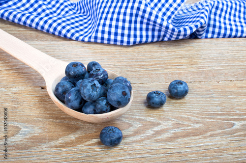 blueberries in spoon on wooden background