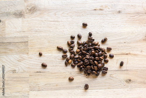 roasted coffee grain on a raw oak table