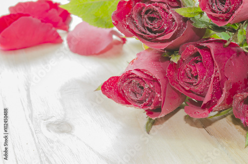 Red roses on a light wooden background