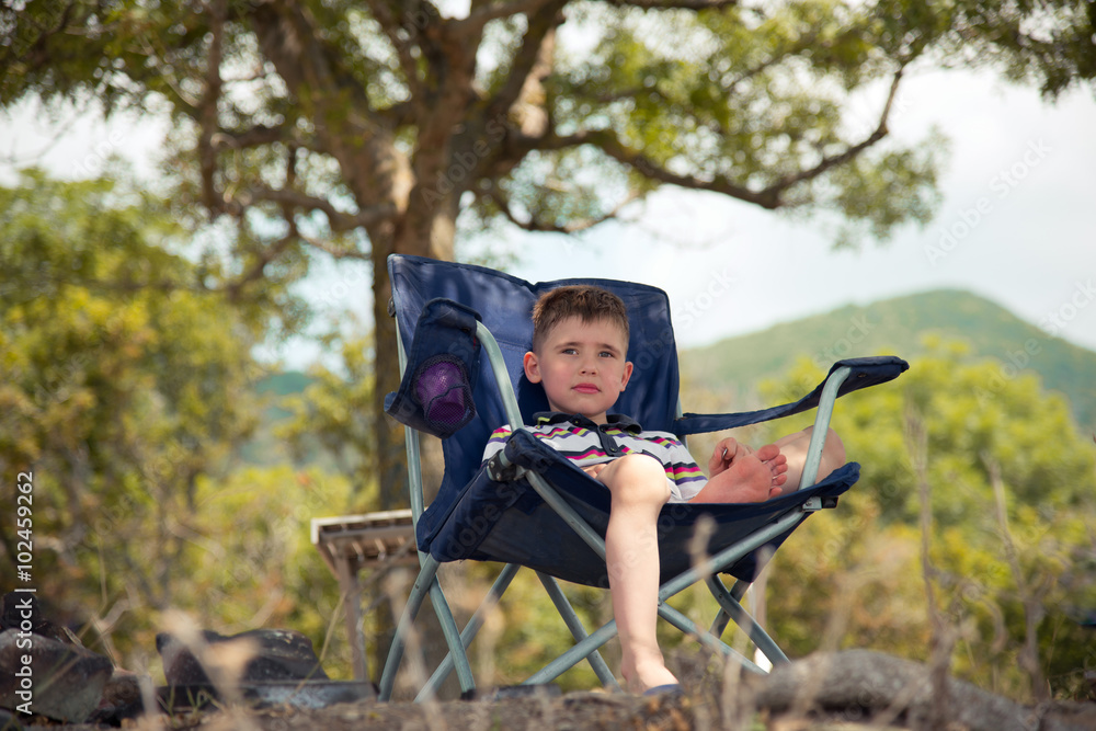 Child resting in a chair at the seaside Child resting in a chair at the seaside