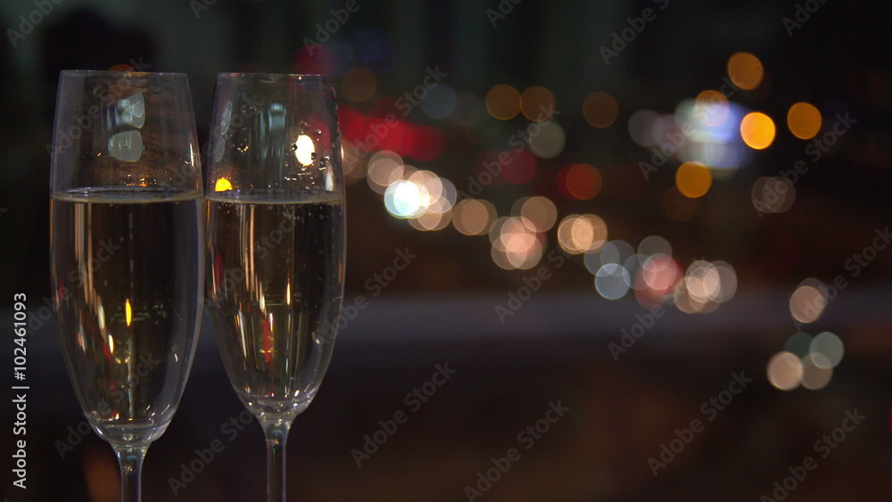 Pair of champaign glasses against a night city lights on background. Pair of champaign glasses against a night city lights on background.