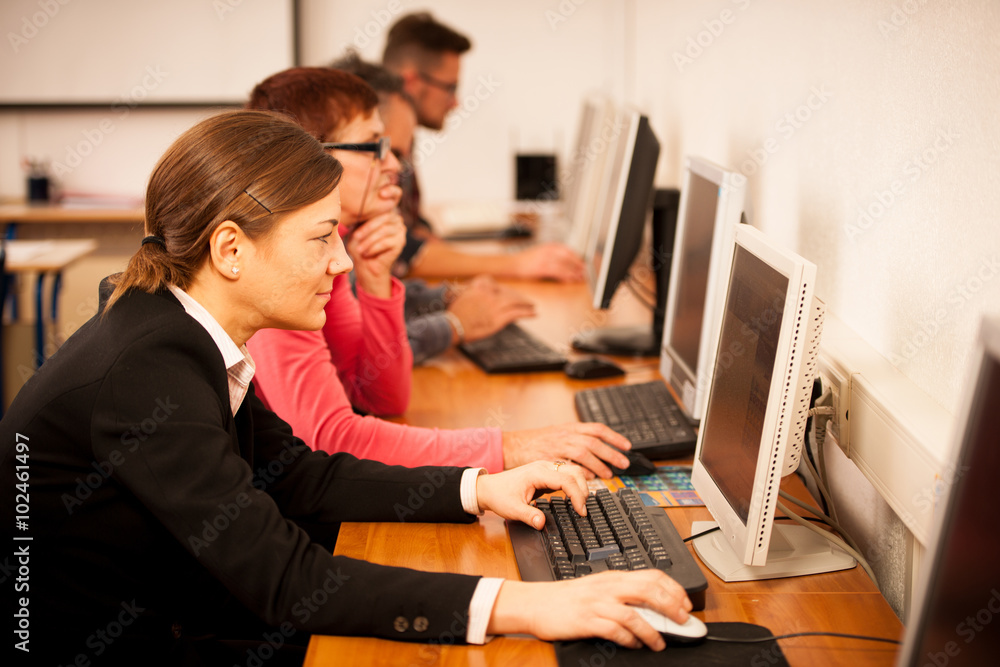 Group of adults learning computer skills. Intergenerational tran Group of adults learning computer skills. Intergenerational tran