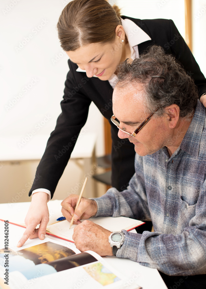 Young teacher explaining somethng to eldery man. Intergeneration Young teacher explaining somethng to eldery man. Intergeneration