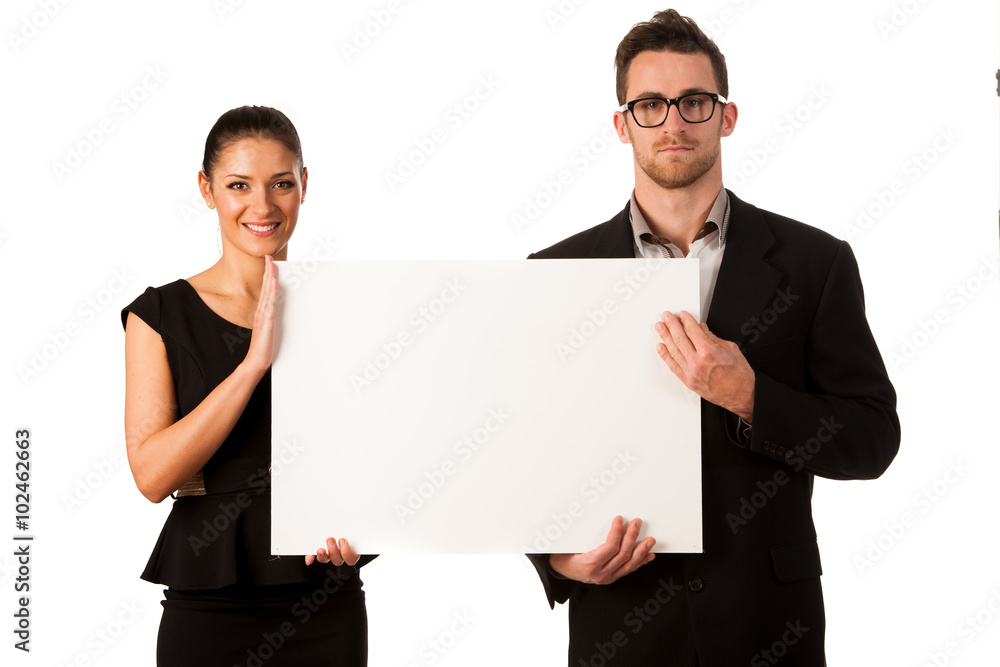 Confident business couple standing next to a big blank board to Confident business couple standing next to a big blank board to