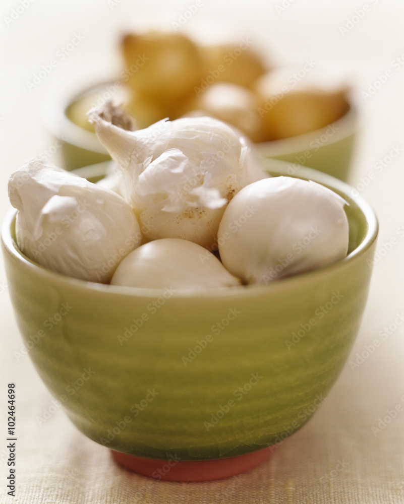 Onions and shallots, close-up in a green bowl. Onions and shallots, close-up in a green bowl.