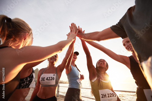 Group of athletes high fiving after race
