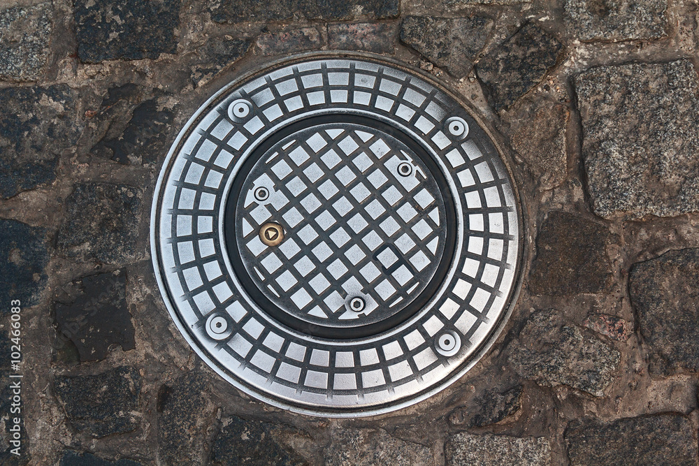 Modern manhole on the stone pavement. Design and Architecture