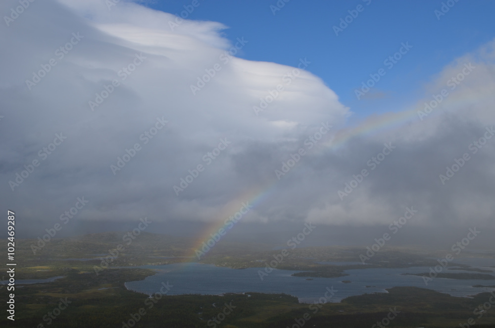 Clouds, rainbow and sunshine over valley in subarctic mountains, Swedish Lapland Clouds, rainbow and sunshine over valley in subarctic mountains, Swedish Lapland