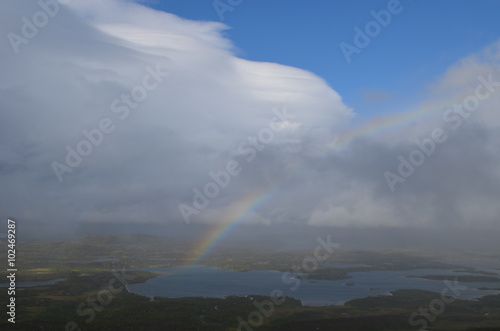 Clouds, rainbow and sunshine over valley in subarctic mountains, Swedish Lapland