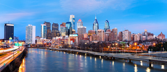 Philadelphia skyline panorama at dusk.  Schuylkill expressway traffic runs parallel to Schuylkill river.