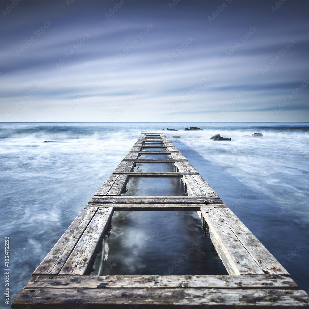 Wooden pier or jetty on a blue ocean. Long Exposure