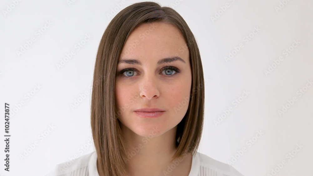 Serious woman looking at camera, takes a look to the right and looks at camera again Serious woman looking at camera, takes a look to the right and looks at camera again