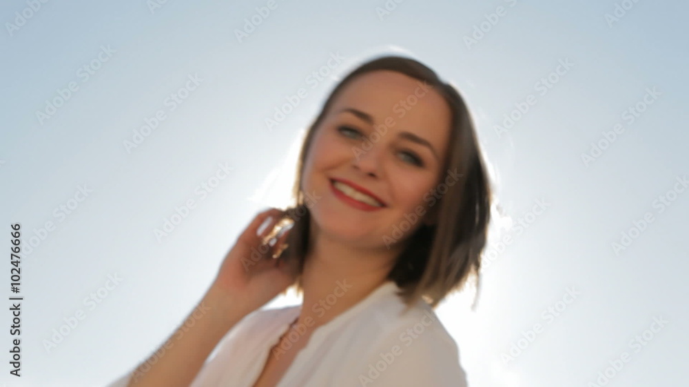 Happy woman dances outdoors with the sun and the sky as background Happy woman dances outdoors with the sun and the sky as background