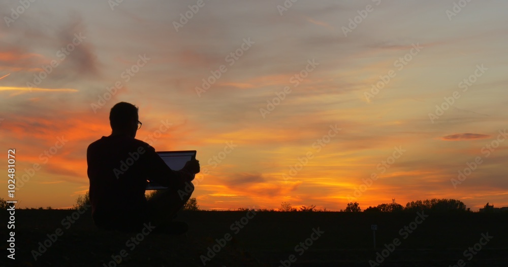 Man in Glasses Man's Silhouette is Sitting at The Field Working with Laptop Freelance Programmer Designer Freelance Copywriter Accountant Going to Leave Man in Glasses Man's Silhouette is Sitting at The Field Working with Laptop Freelance Programmer Designer Freelance Copywriter Accountant Going to Leave