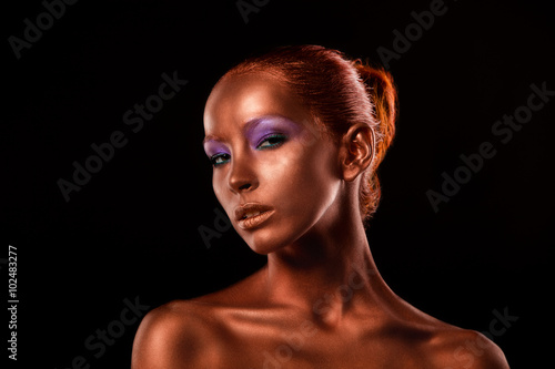 Gilt. Golden Woman's Face Closeup. Futuristic Gilded Make-up. Painted Skin bronze.
