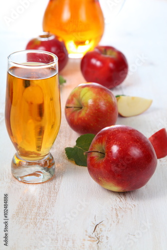 Apple juice and apples on a wooden table