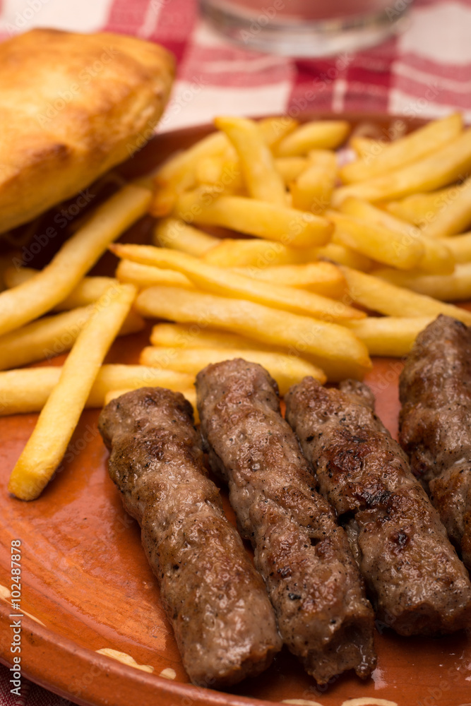 French fries with kebabs and bread bun served French fries with kebabs and bread bun served