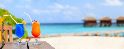 Fototapeta Naklejka Na Ścianę i Meble -  Two cocktails on luxury beach resort, wide panorama