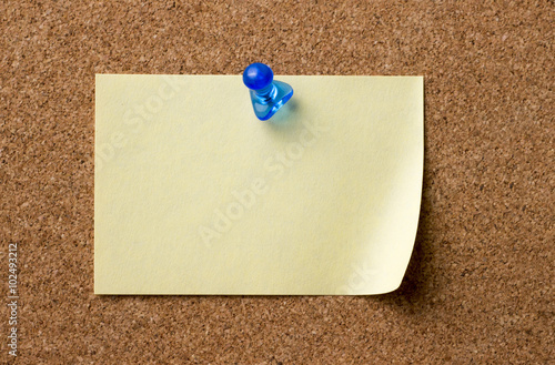 Blank adhesive label pinned on bulletin board