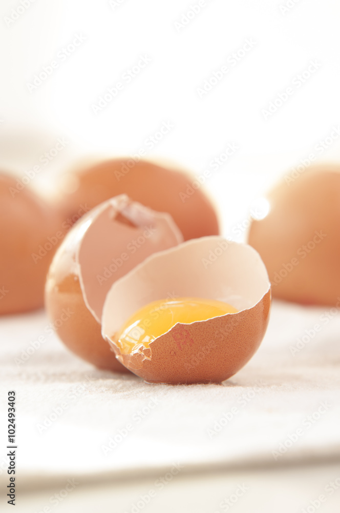 With brown eggs on a white background. One egg is broken. With brown eggs on a white background. One egg is broken.