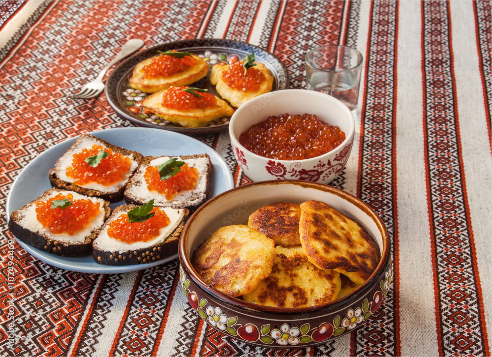 Thick potato pancakes and red caviar on a table (mass produced p Thick potato pancakes and red caviar on a table (mass produced p