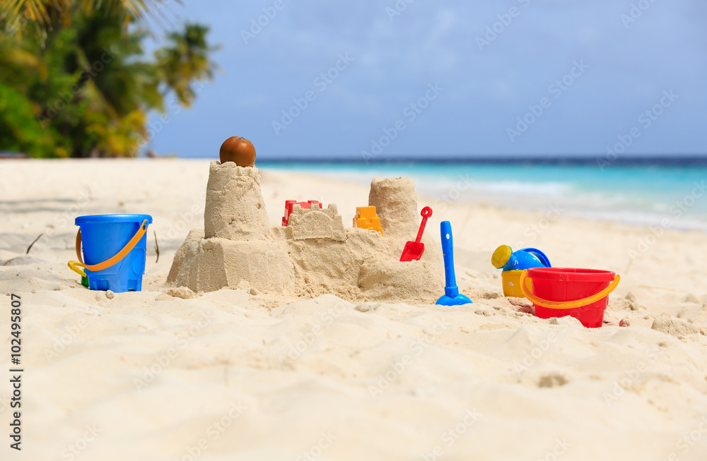 Sand castle on tropical beach and kids toys Sand castle on tropical beach and kids toys