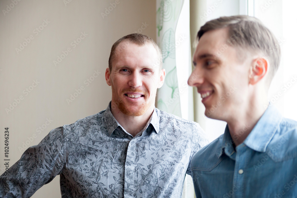 brothers standing at window brothers standing at window