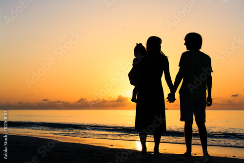 romantic couple with little child at sunset tropical beach © nadezhda1906