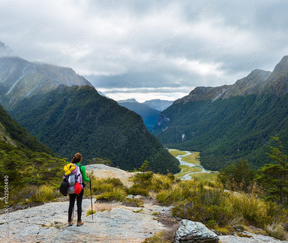 woman hiker with backpack looking at the view of Routeburn Flat