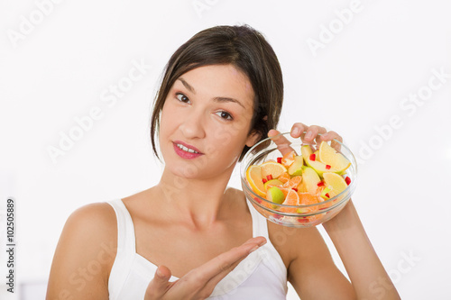 Beautiful girl holding a bowl of fresh healthy fruit salad