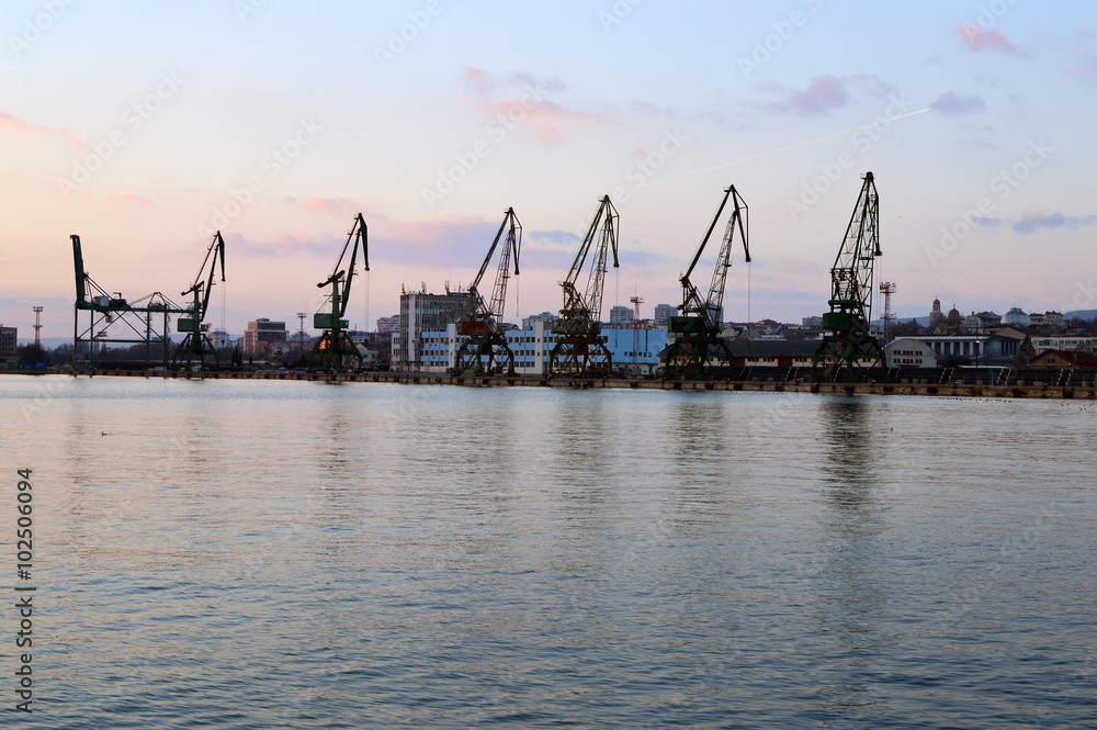 Cargo docks with dark cranes’ silhouettes after sunset, Varna Harbor, Bulgaria