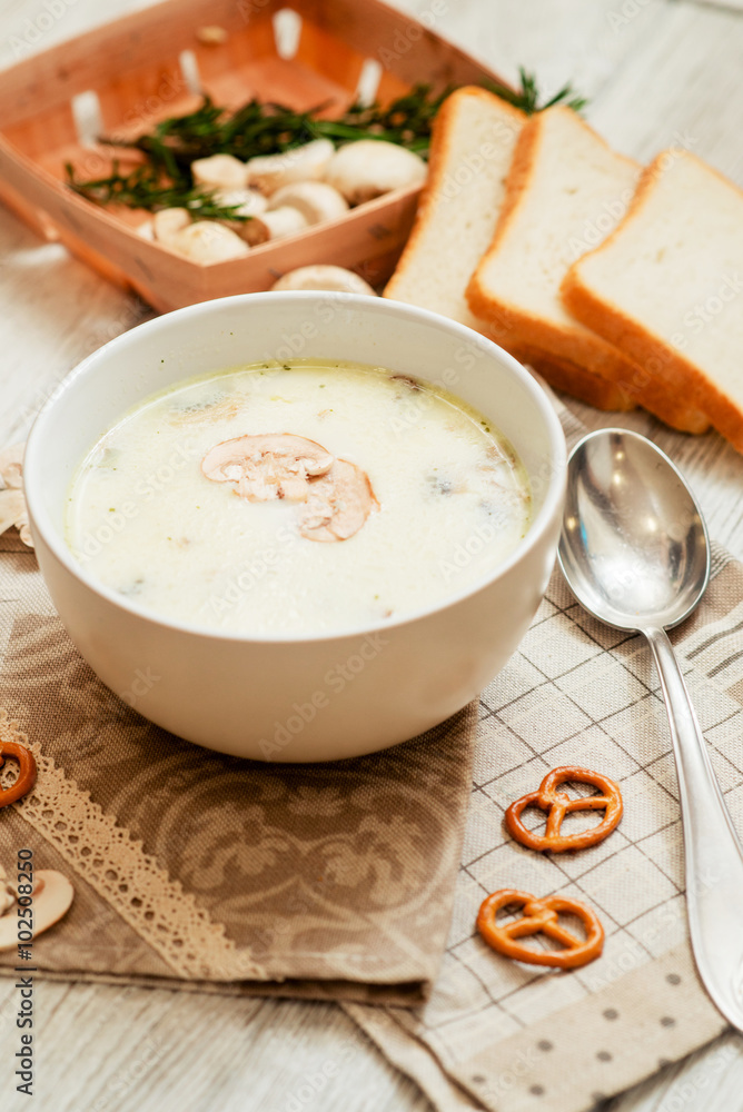 
mushroom soup with potatoes , carrots , green and white toast on a wooden background