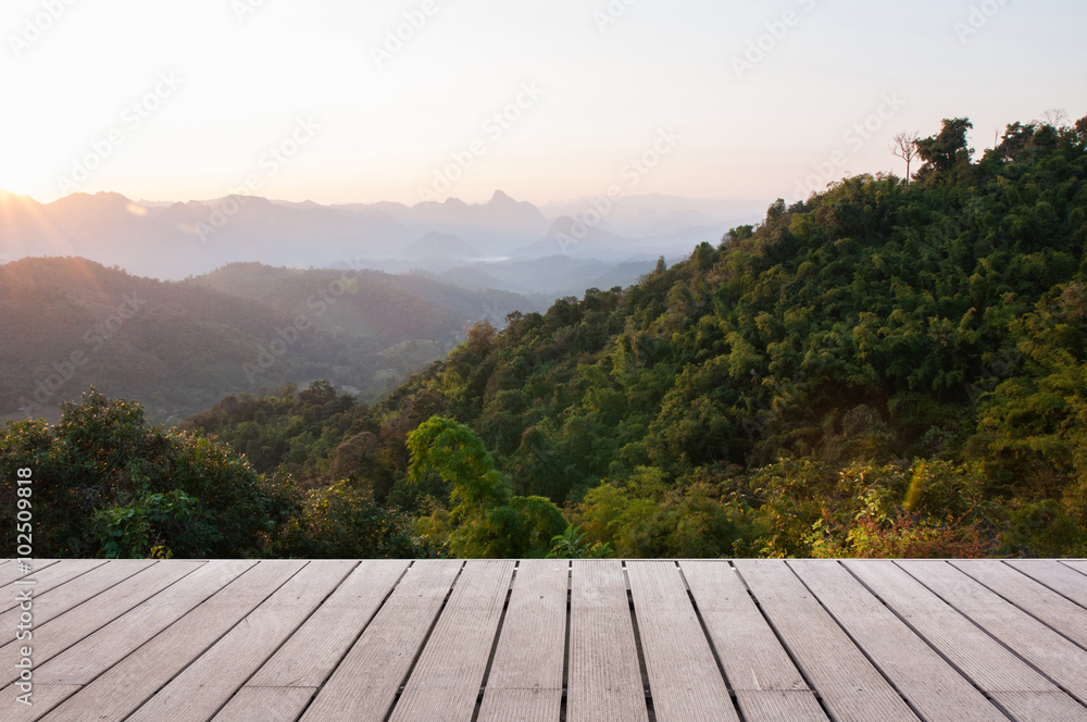 Wood table top on Majestic sunset in the mountains landscape Wood table top on Majestic sunset in the mountains landscape