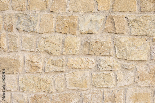 Old beige stone wall background texture