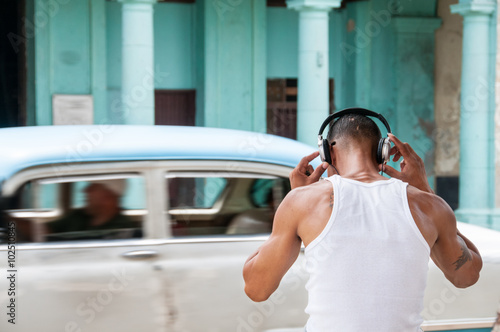 Photography boy listening to music with headphones in the street
