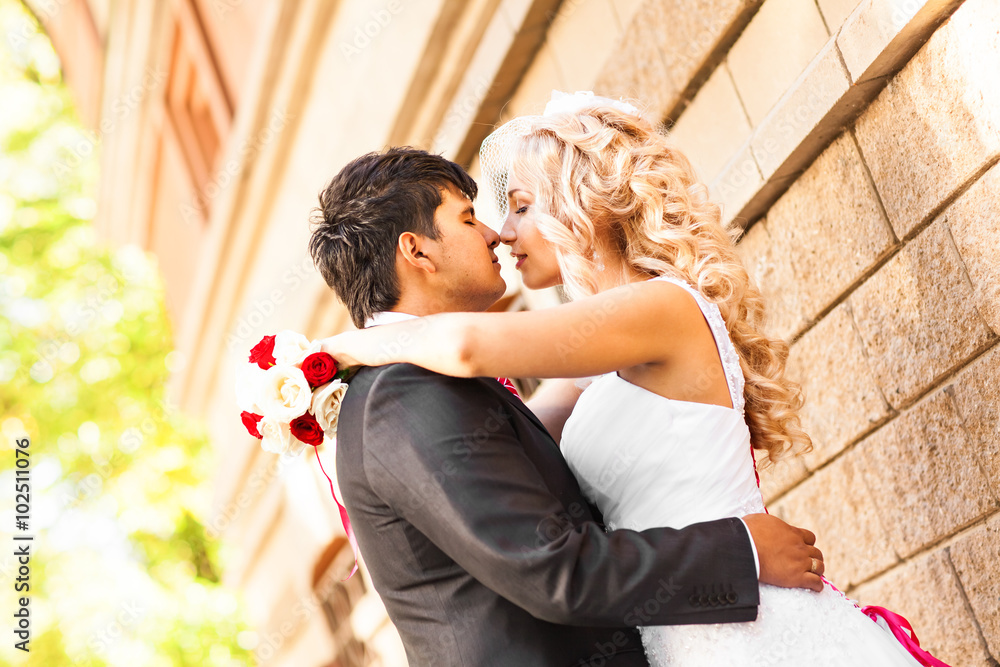 Fototapeta premium Groom kissing bride on their wedding day