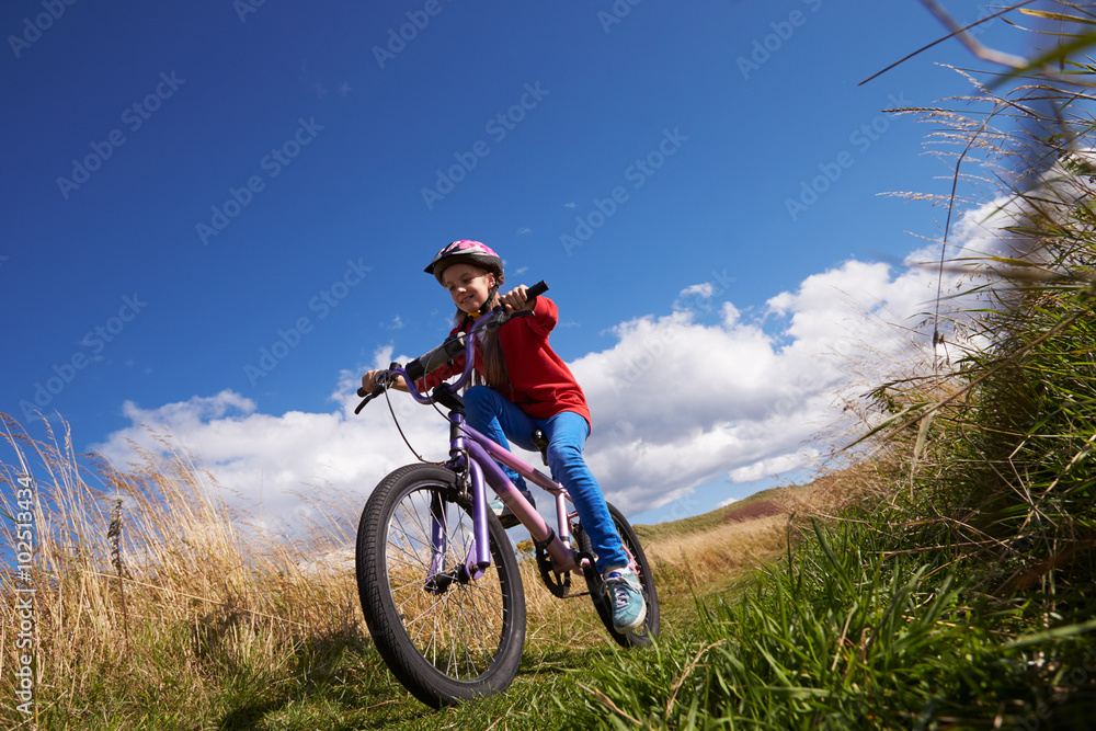 Low Angle Shot Of Girl Riding Bike Through Countryside