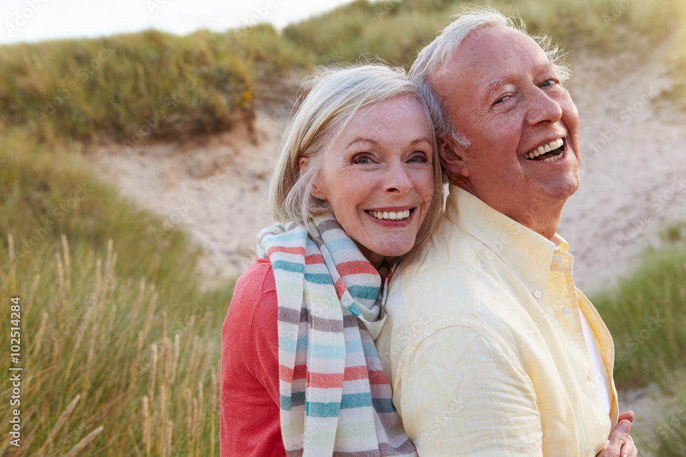 Portrait Of Senior Couple Standing By Sand Dunes