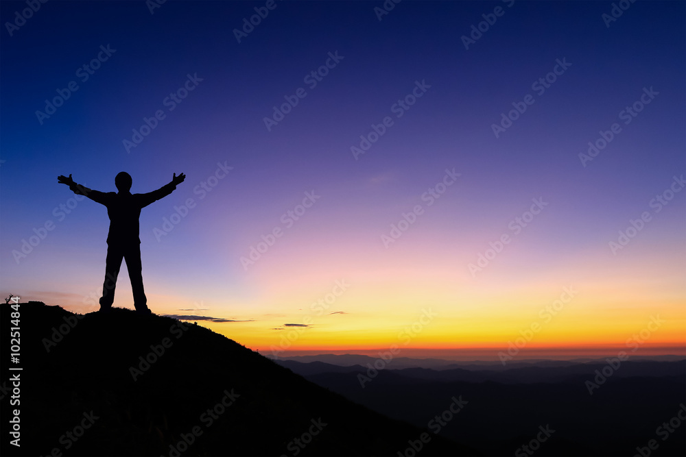 Silhouette of man standing and spread hand on the top of mountain