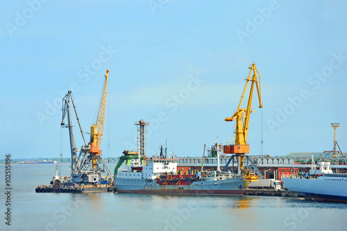Pump-dredge ship under port crane