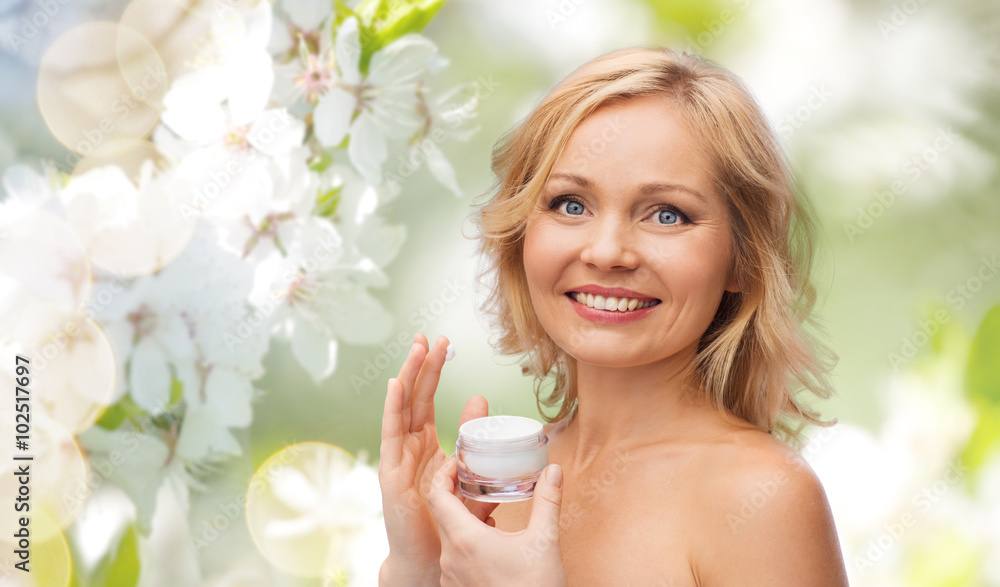 happy woman applying cream to her face