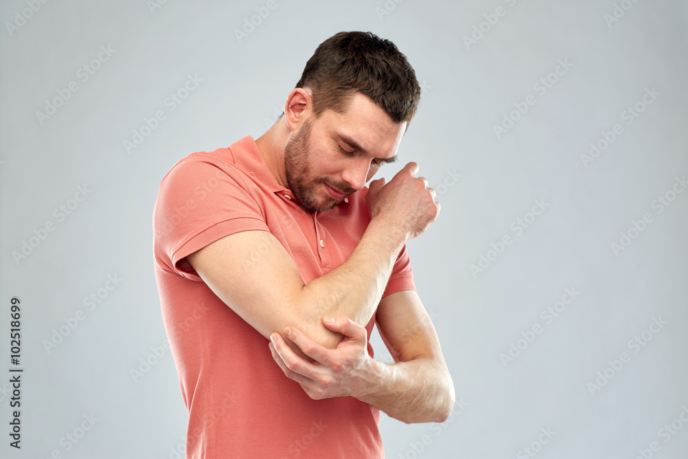 unhappy man suffering from pain in hand unhappy man suffering from pain in hand