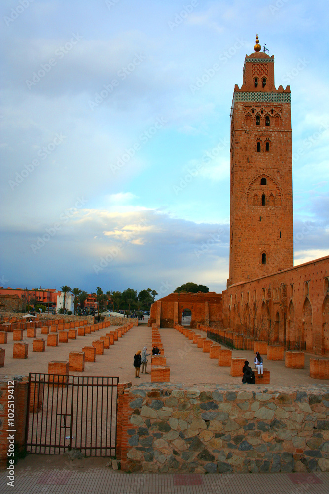Mosque of Koutoubia. Marrakesh, Morocco - February 24, 2012: People walking towards the Koutoubia mosque in the center of Marrakesh in the evening