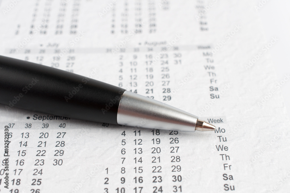 Black ballpoint pen on a calendar Black ballpoint pen on a calendar