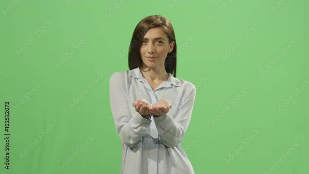 Woman presents a virtual gift on a mock-up green screen in the background. Shot on RED Cinema Camera. Woman presents a virtual gift on a mock-up green screen in the background. Shot on RED Cinema Camera.